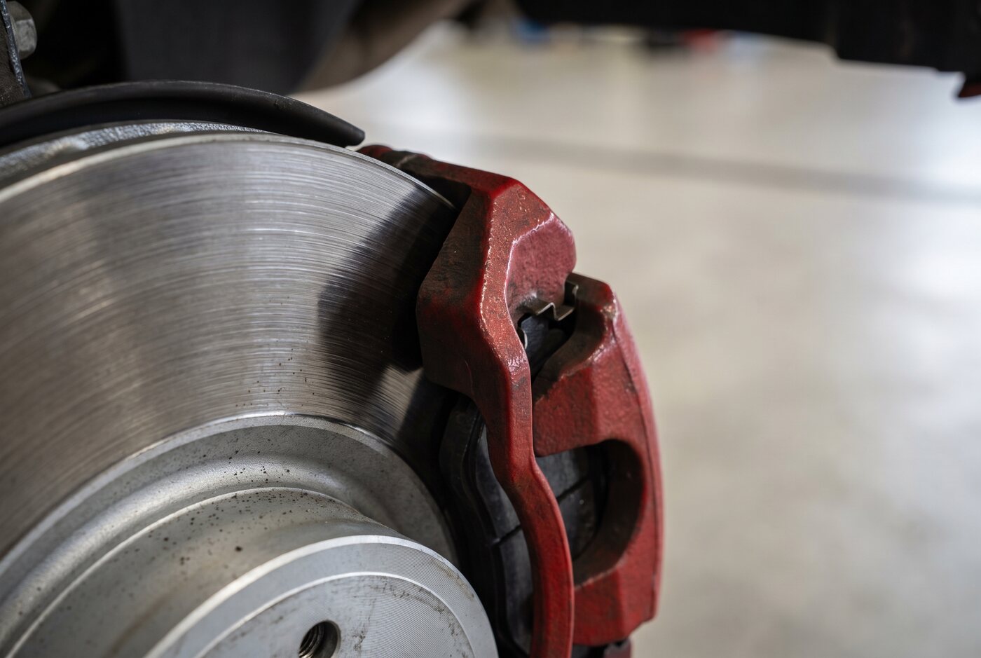 Close-up of a vented brake rotor and caliper with new brake pads