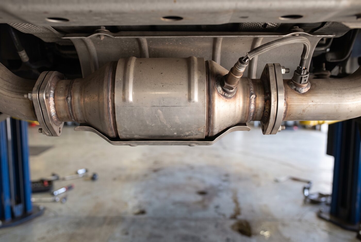 Catalytic converter section and heat shield under a vehicle on a lift